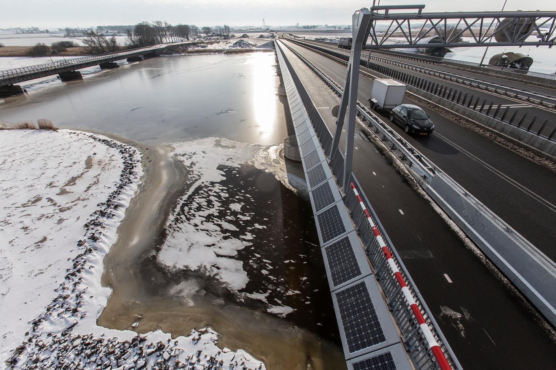 Twee bruggen over een rivier in een winterlandschap.